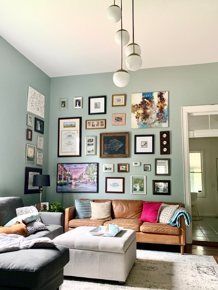 A stylish living room set up with a gallery made of mixed frame art.