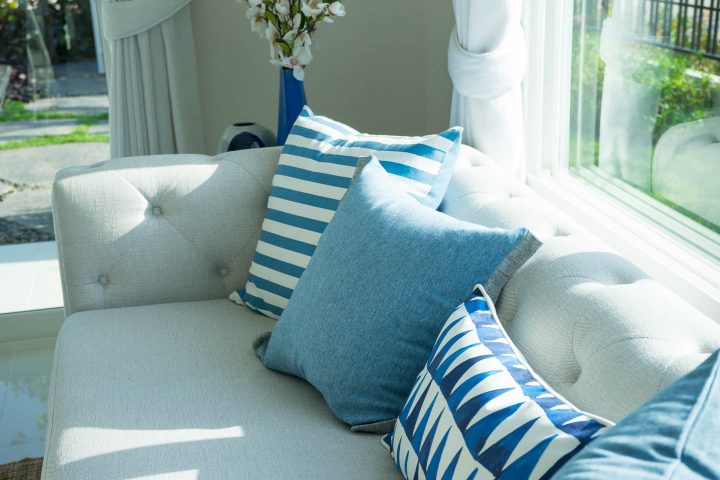 neutral gray sofa with bright blue and white cushions