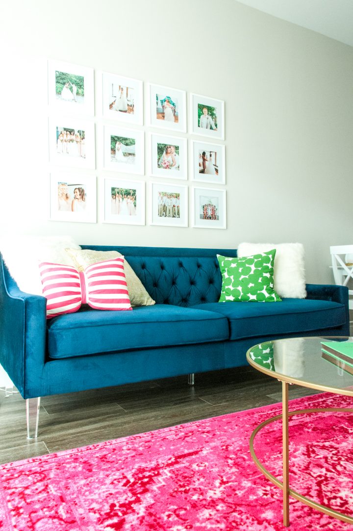 Gallery style family photos using vertical space on a wall behind a modern blue couch.