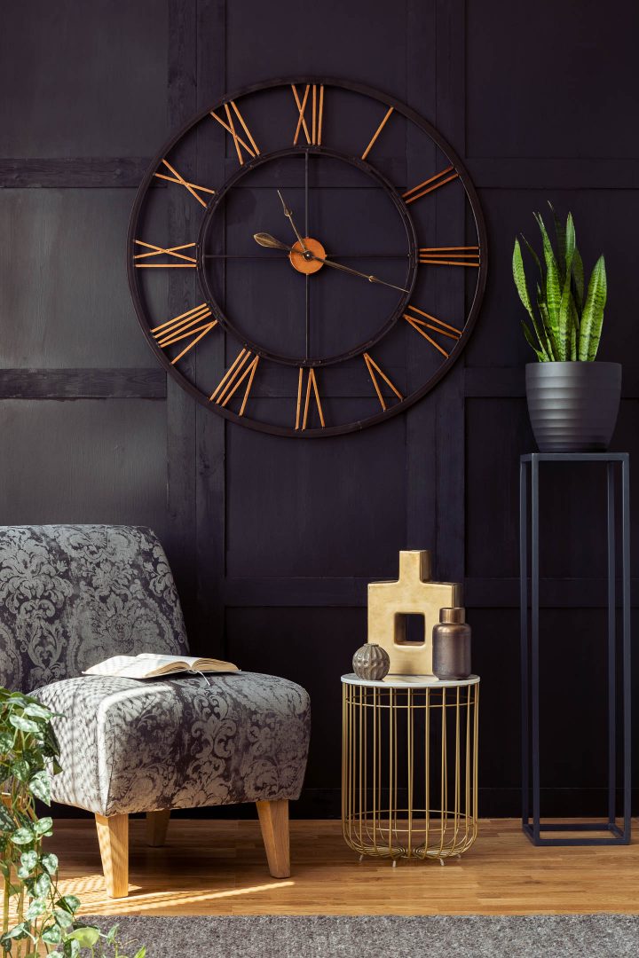 Living room accent wall painted black with a large clock on it