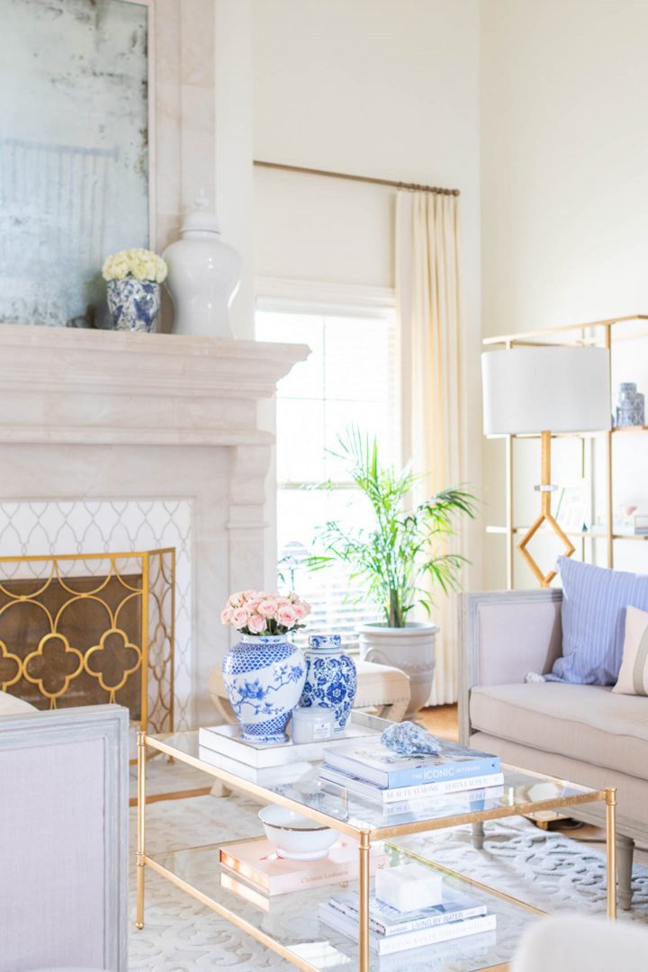 Living room with blue, white and gold accents, and walls painted with Sherwin Williams Dover White (©jennifermaune.com)