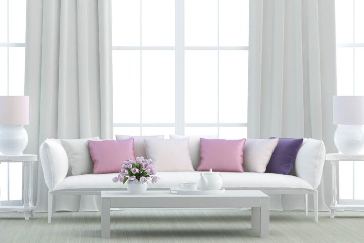 white living room with pink and purple throw cushions