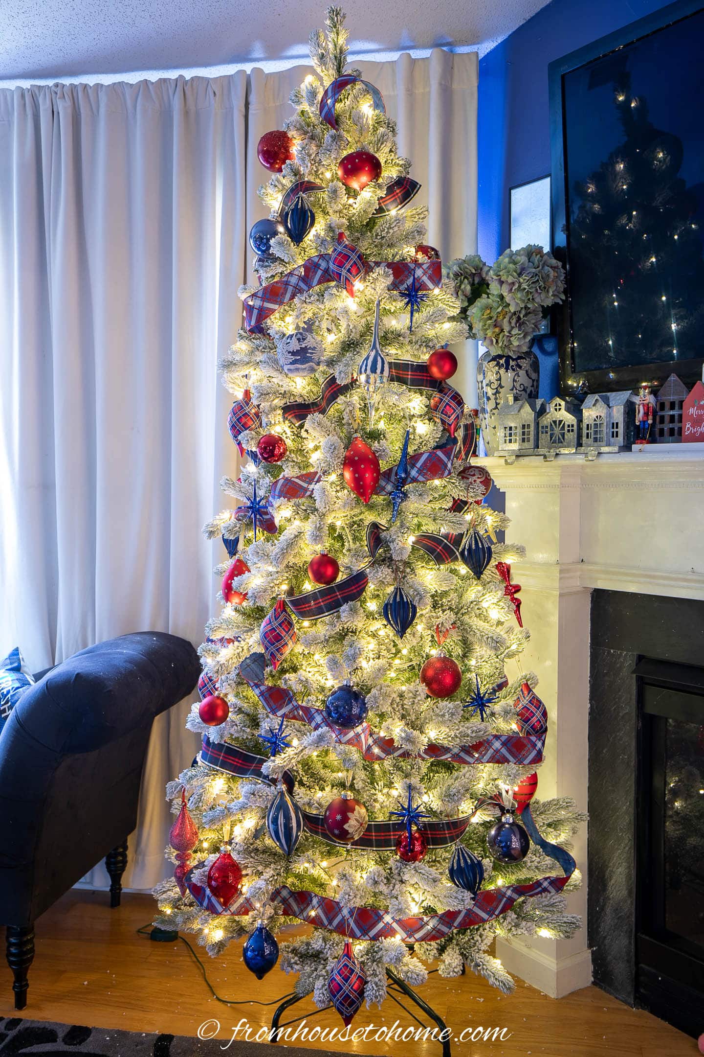 Christmas tree with dark blue ornaments, red ornaments and red and blue plaid ribbon
