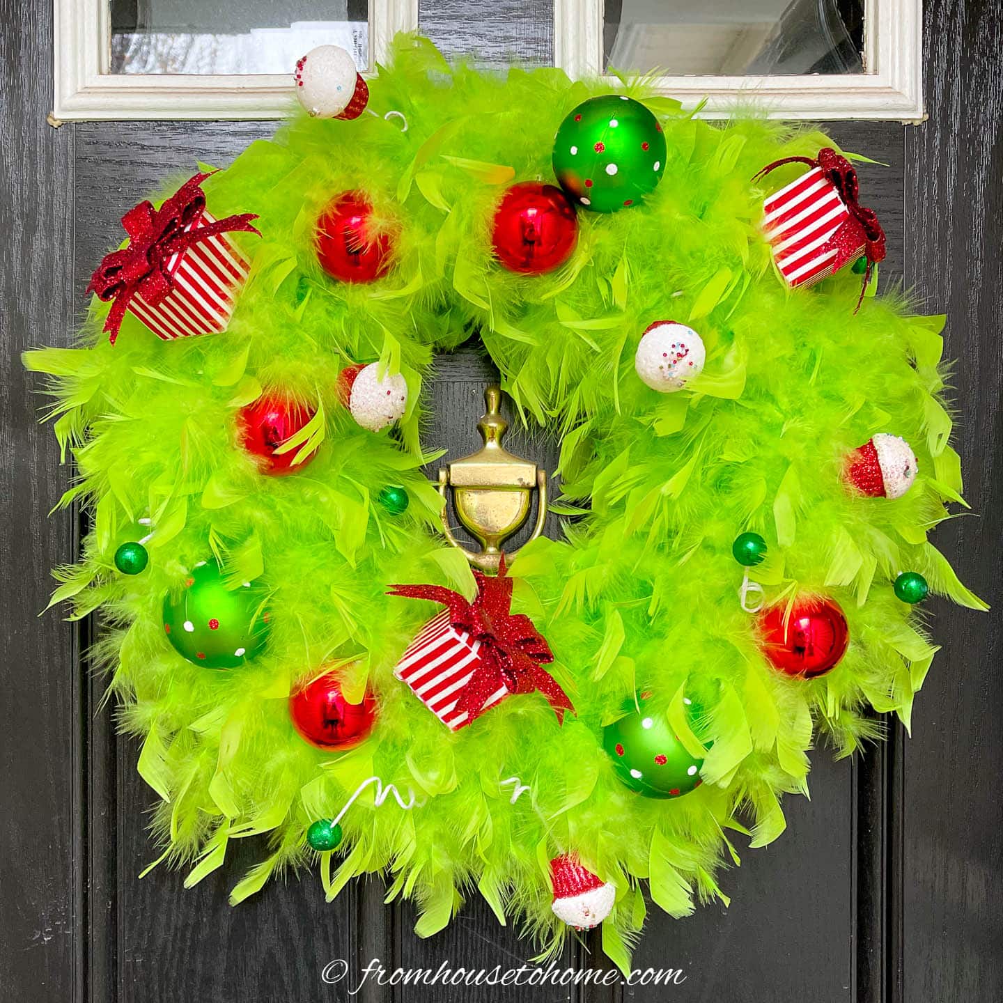 DIY Grinch wreath hanging on a black door