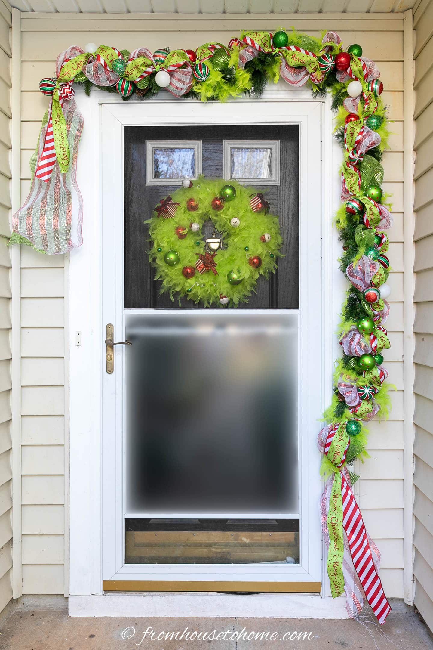 DIY Grinch garland over a front door with a Grinch wreath on it