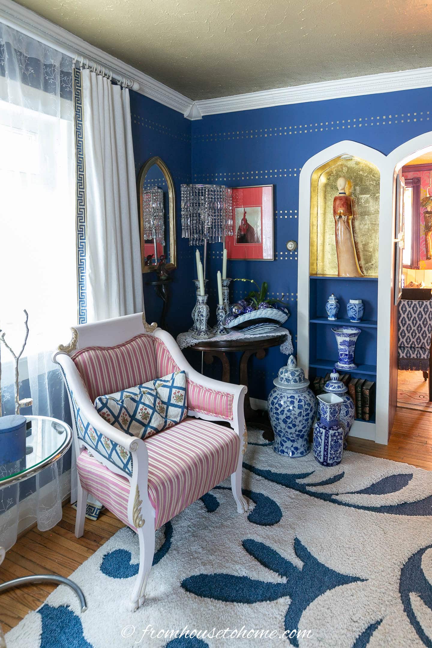 lots of blue and white jars in a living room with blue walls, white trim and  gold ceiling