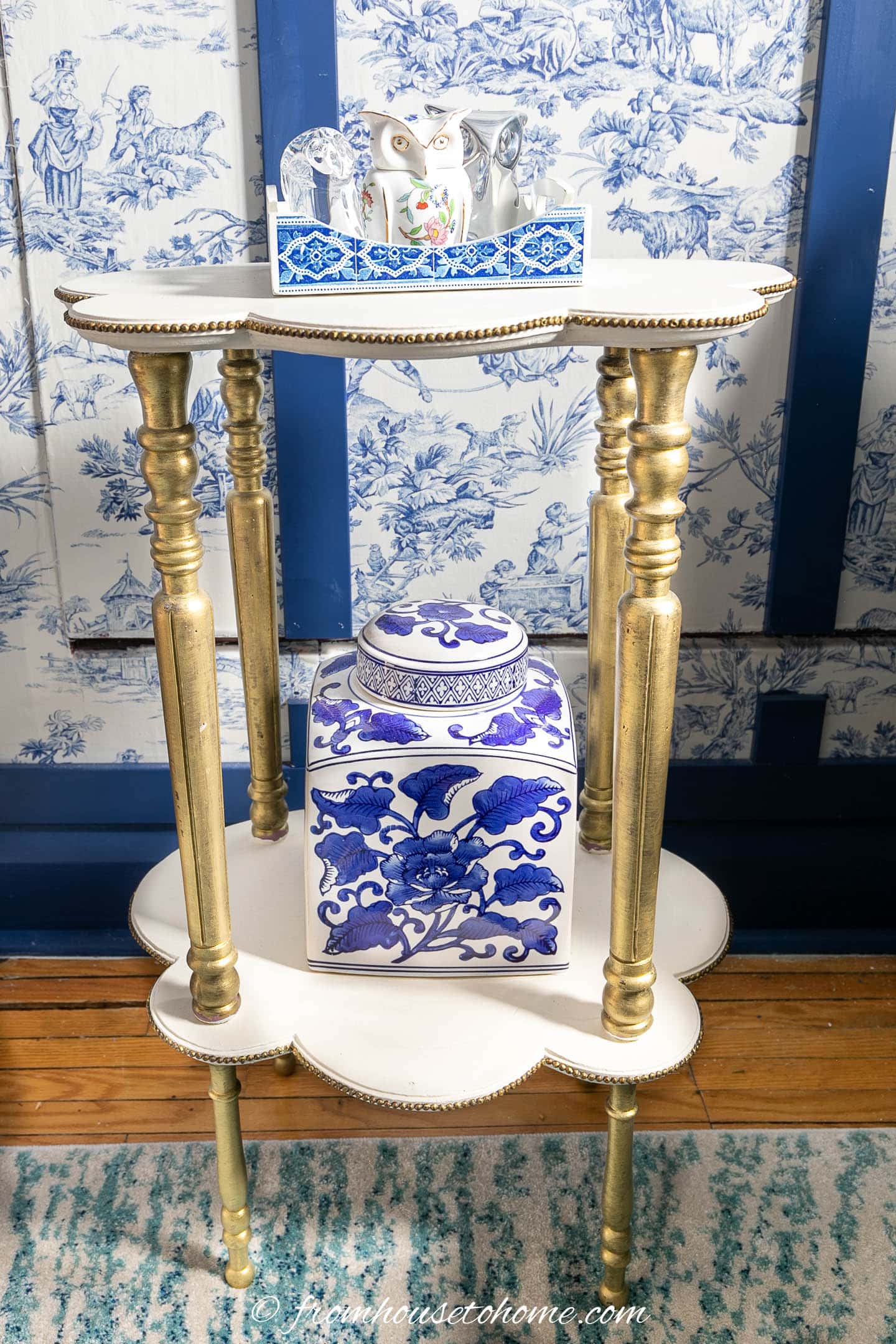 white and gold tiered table in a blue and white room