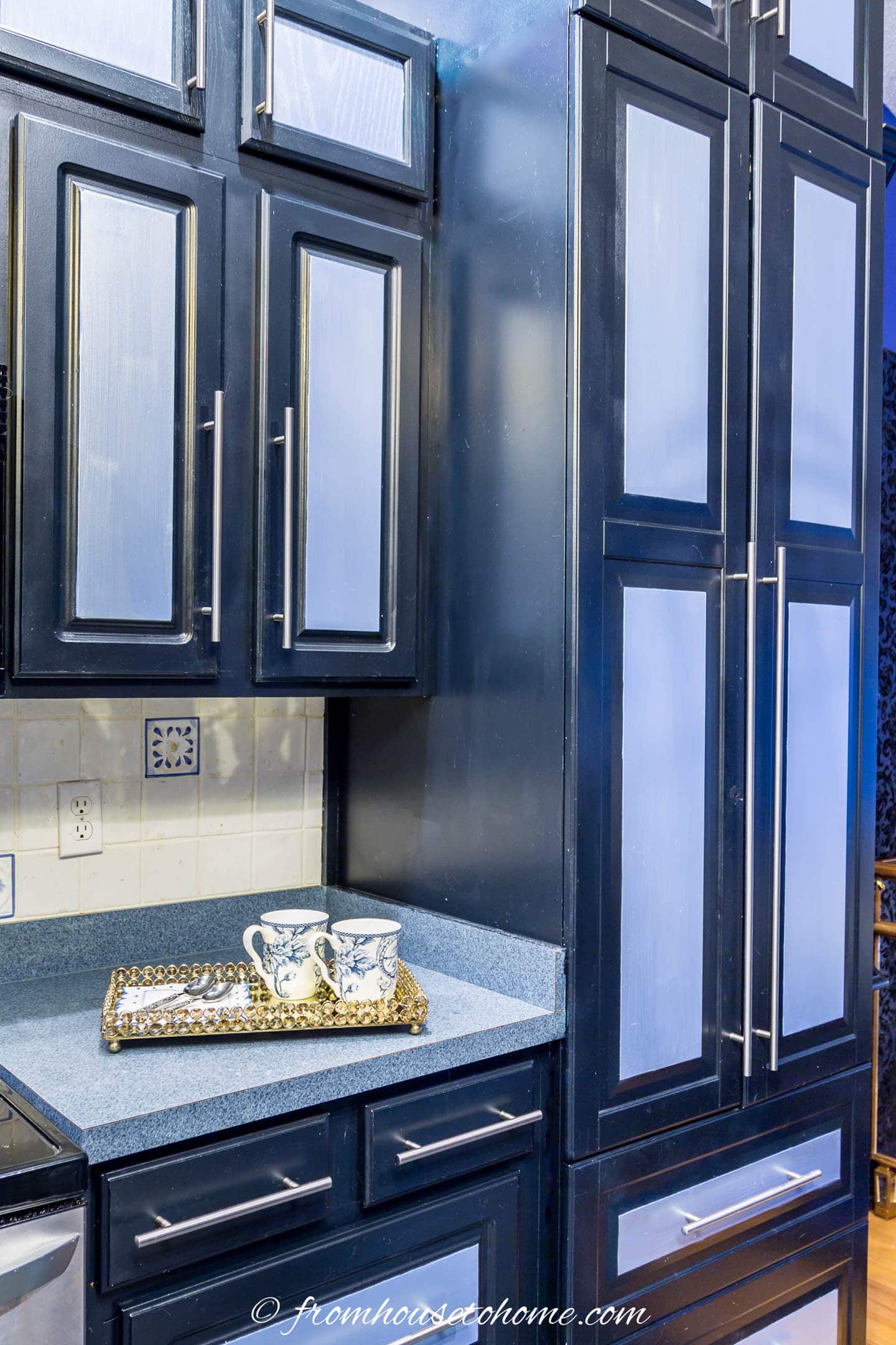 kitchen cabinets painted with black and blue paint and silver glaze