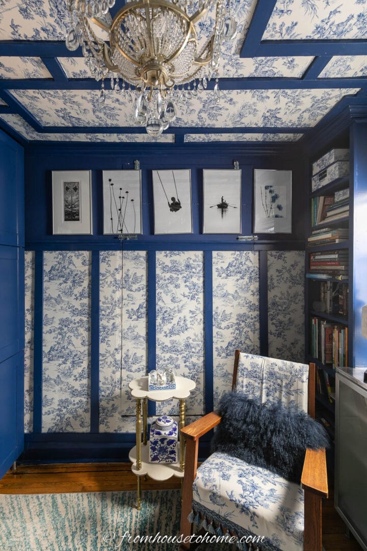 A wall with panels filled in with blue and white toile fabric