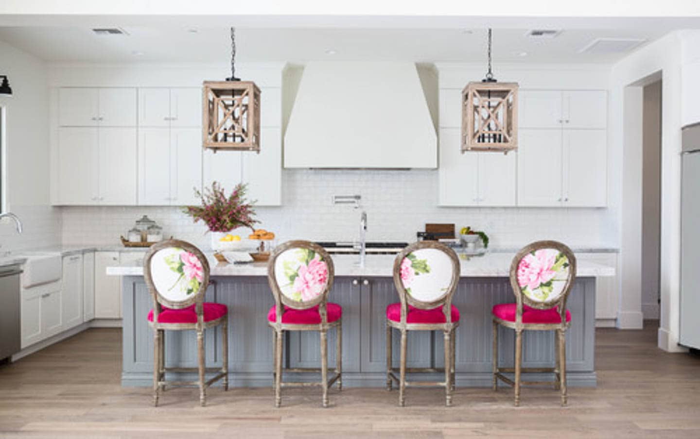 Gray and white kitchen with chairs upholstered in pink fabric