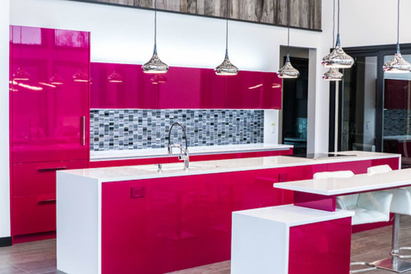 Modern kitchen with high gloss fuchsia cabinets, white waterfall countertops and black and gray backsplash