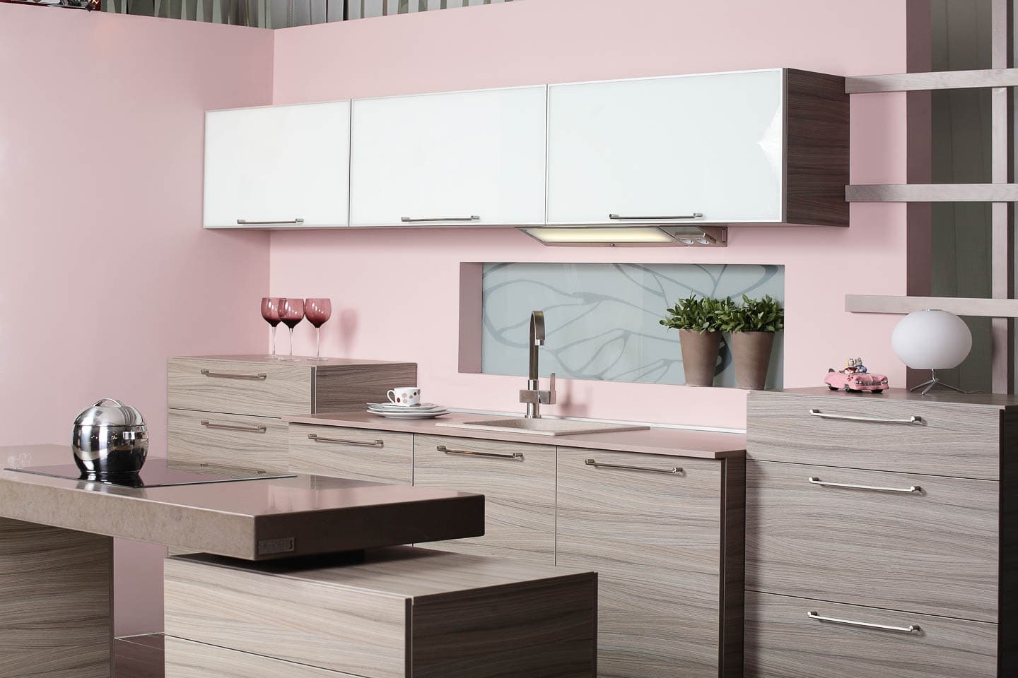 Modern kitchen with gray base cabinets, white upper cabinets and blush pink walls
