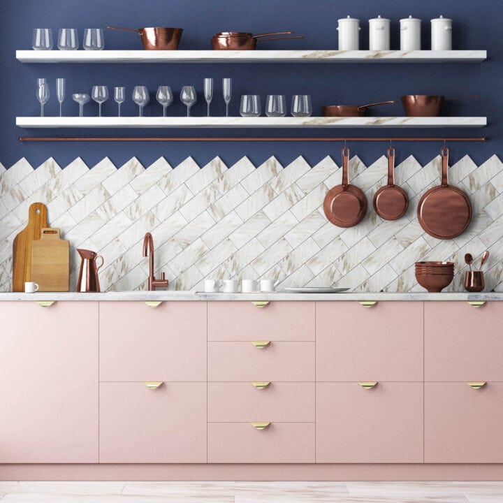 kitchen with navy blue walls, white marble backsplash and pink cabinets