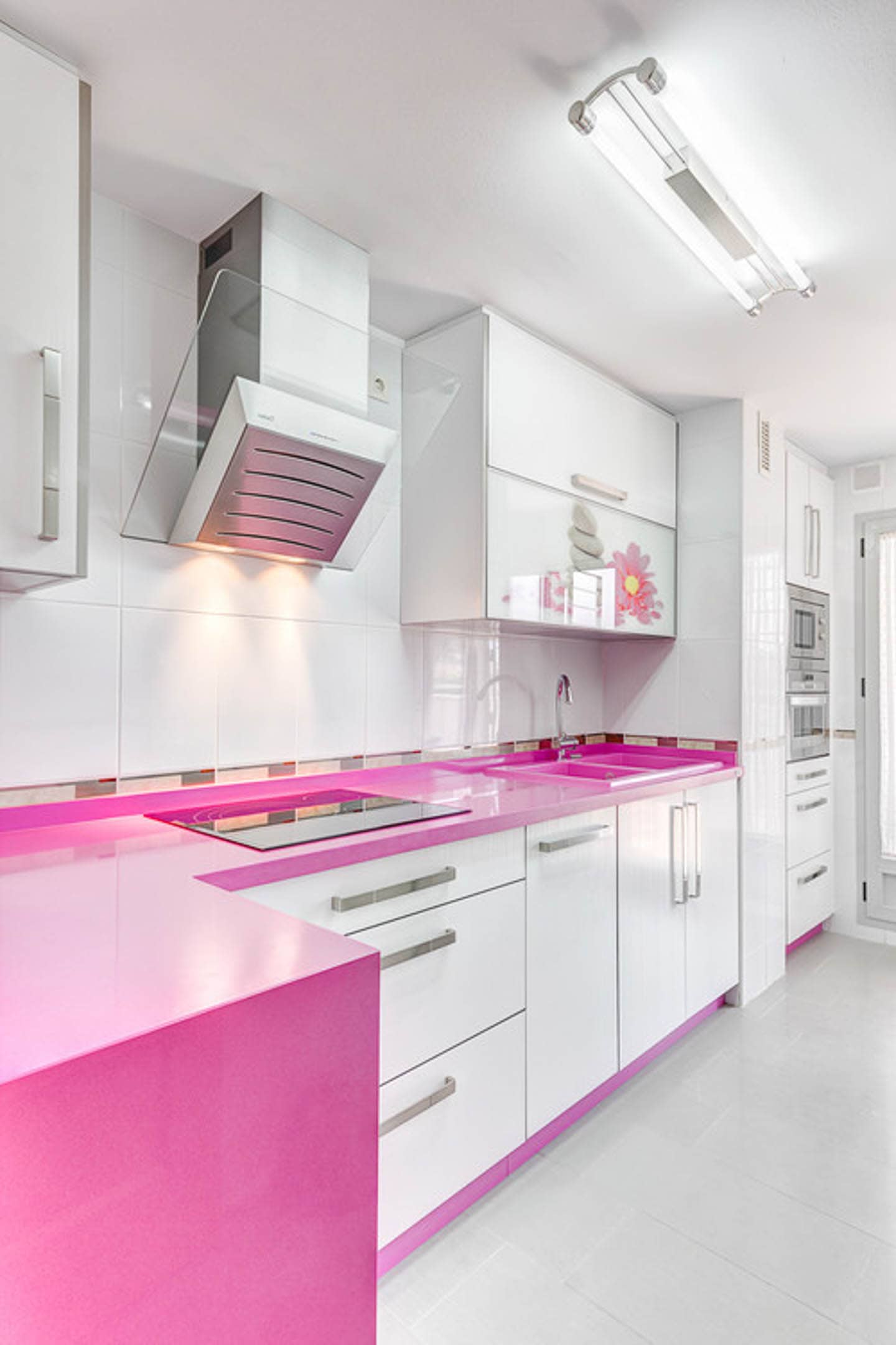 Sleek modern kitchen with white cabinets and a bright pink countertop