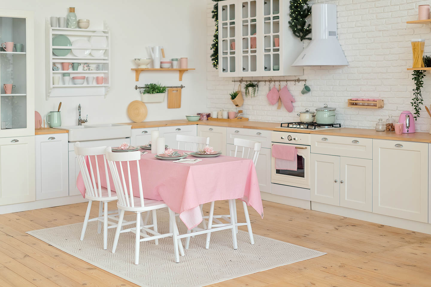white farmhouse kitchen with pink tablecloth, tea towels and other small pink accents