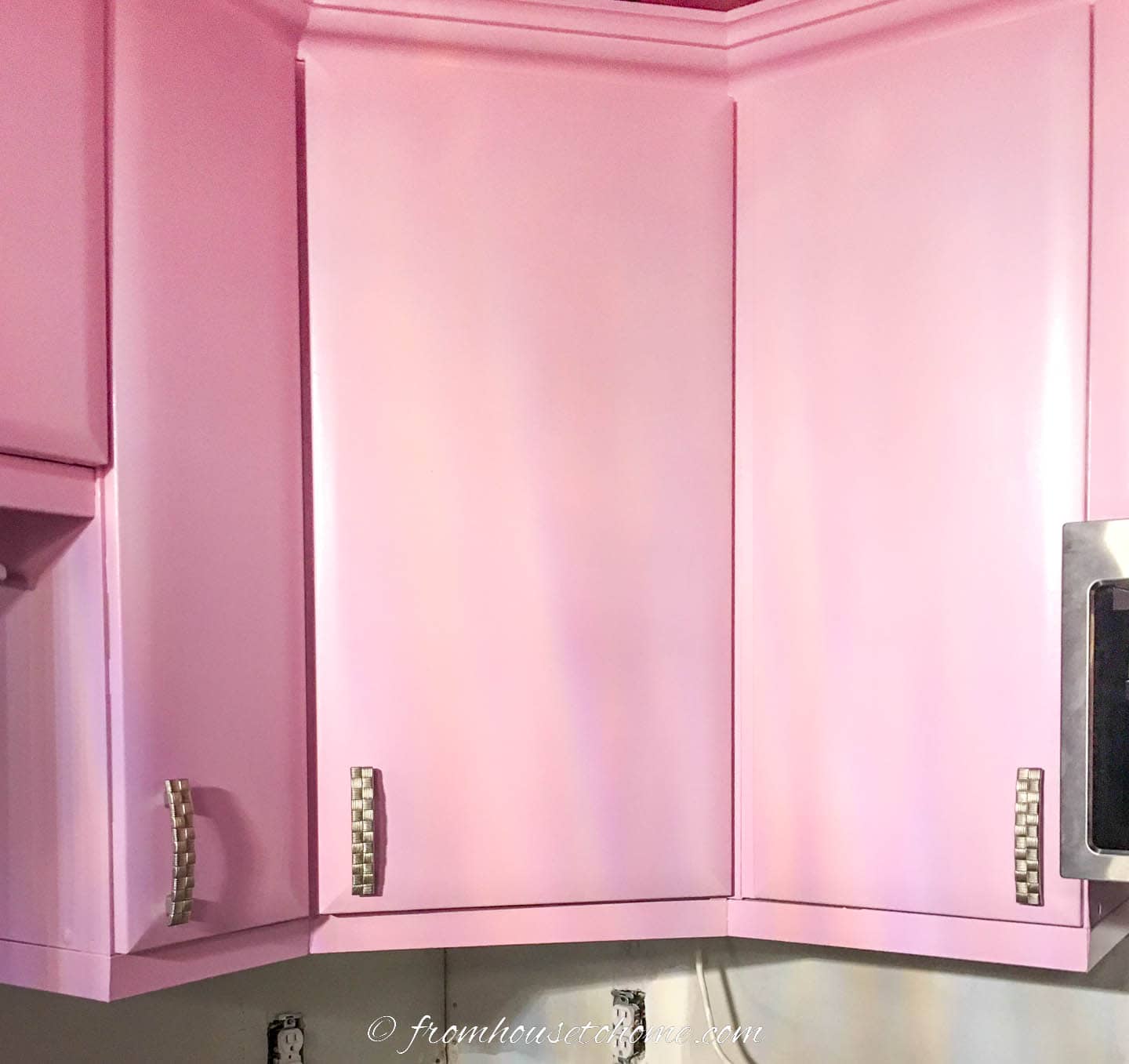 Pink upper kitchen cabinets with brushed pewter pulls