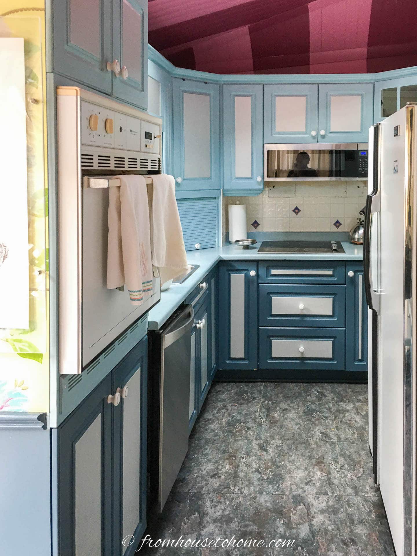 small galley kitchen "before" with blue cabinets and pink ceiling