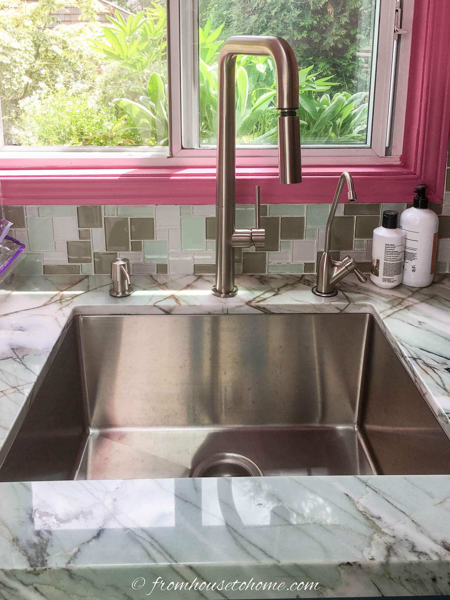 "After" picture of the large single kitchen sink with a tall faucet and soap dispenser