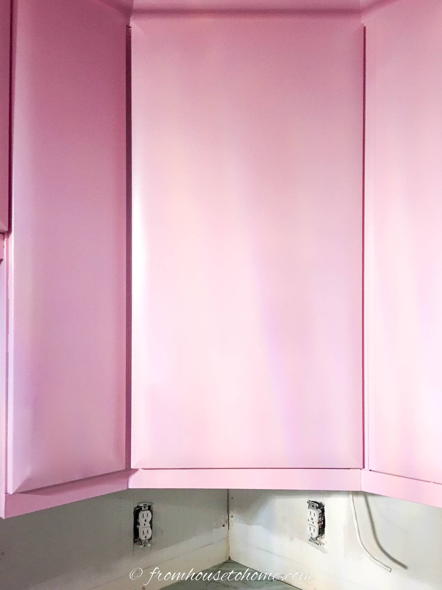 The top kitchen cabinet doors painted light pink (Sherwin Williams 'Irresistible')