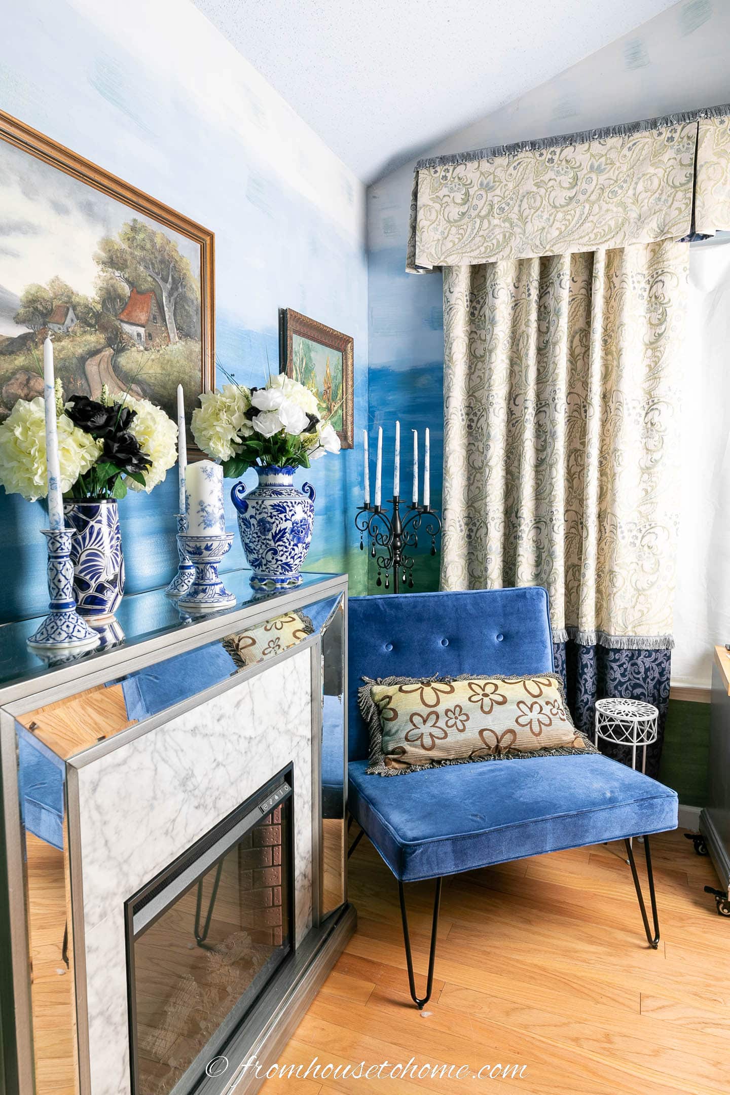 Fireplace and blue chair in a room with blue ombre walls and white and blue curtains