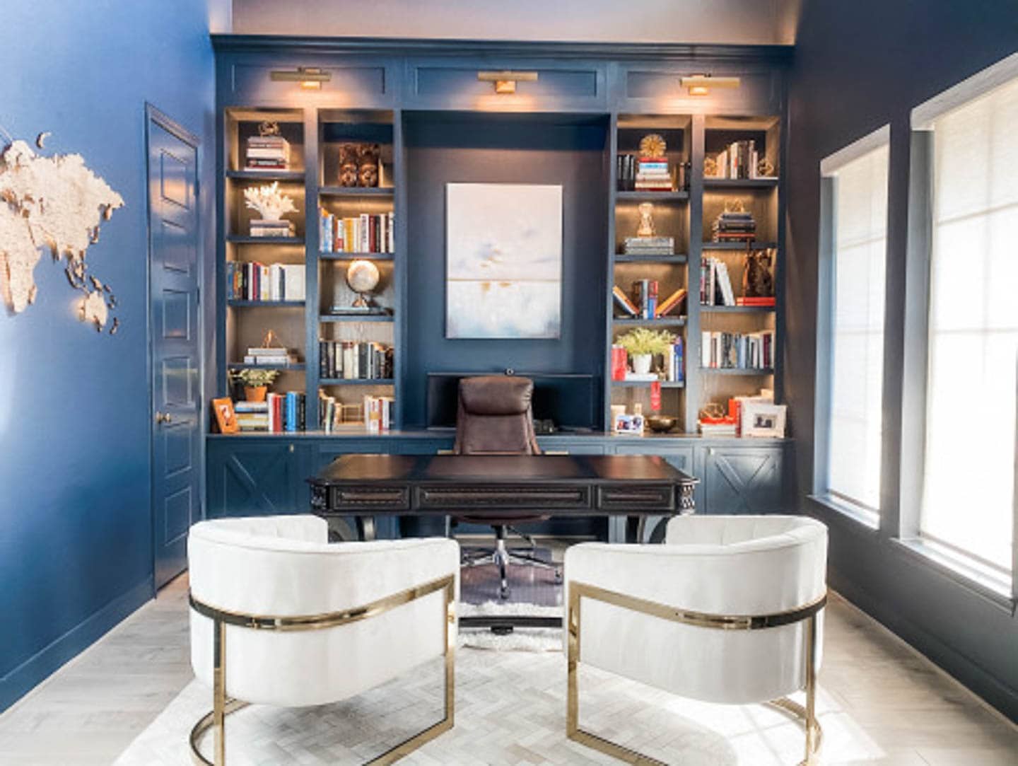 Dark blue home office with a large window, a black desk and 2 white barrel side chairs