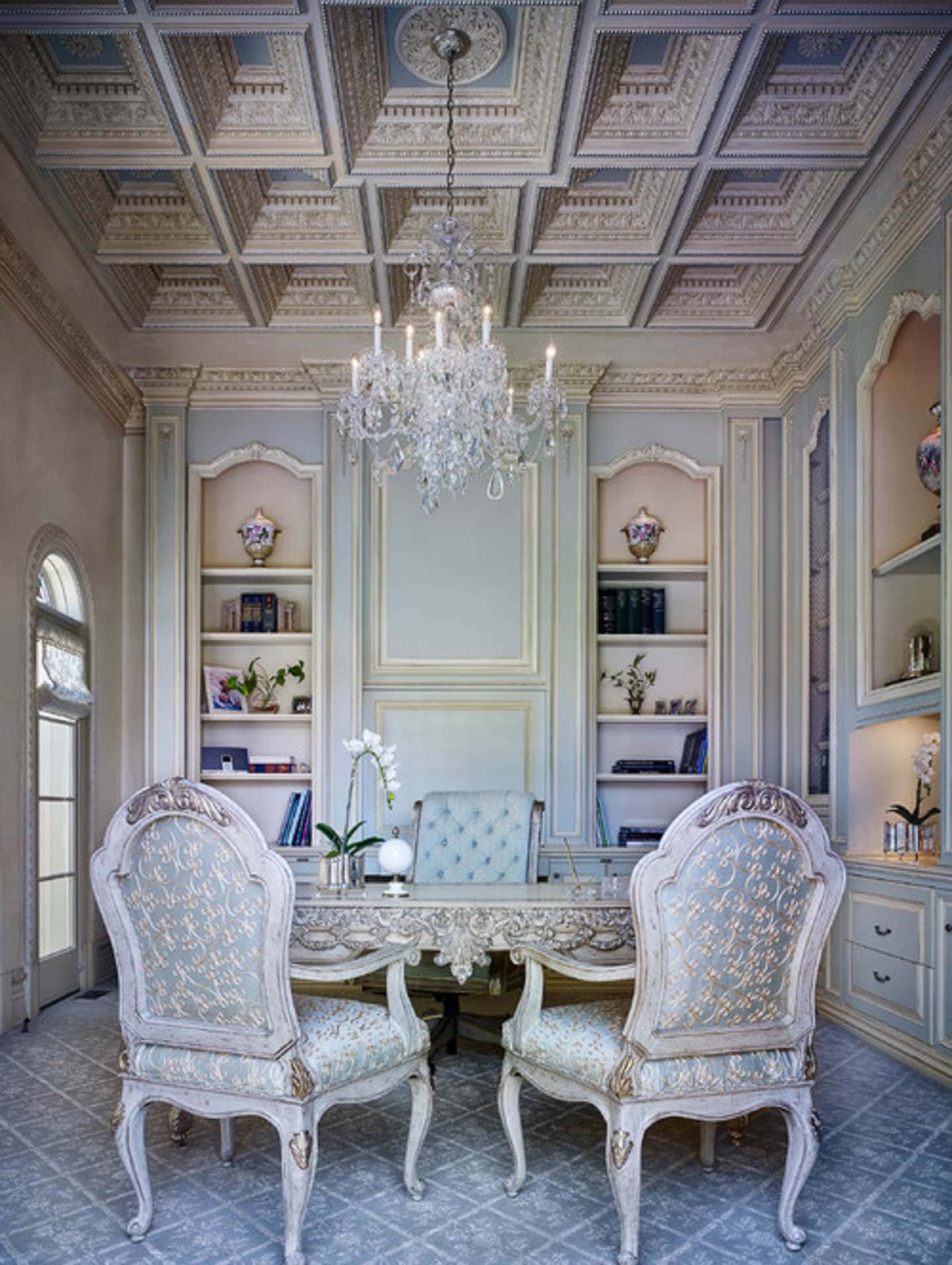 Traditional home office painted light blue with panel moldings painted gold, a coffered ceiling, chandelier and traditional chairs upholstered in light blue