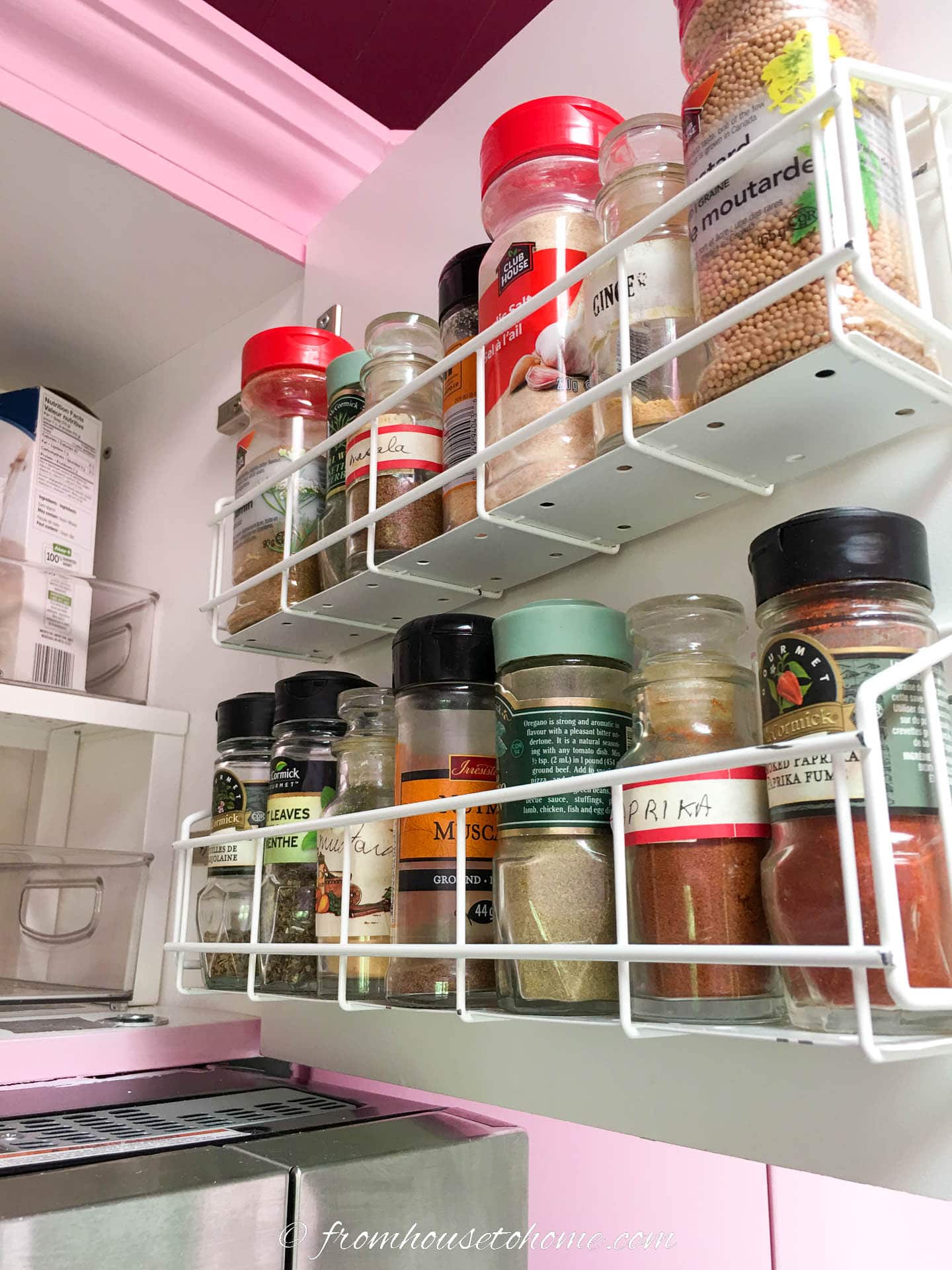 Spices stored in a rack on the inside of a kitchen cabinet door