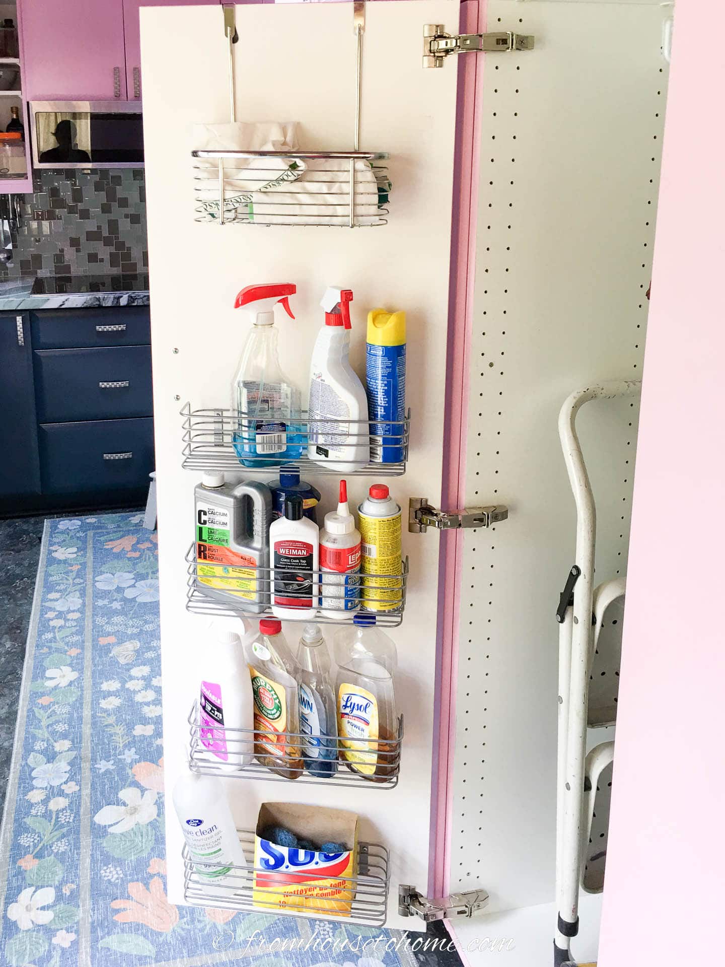 Cleaning supplies in metal racks installed on the inside of a kitchen cabinet door