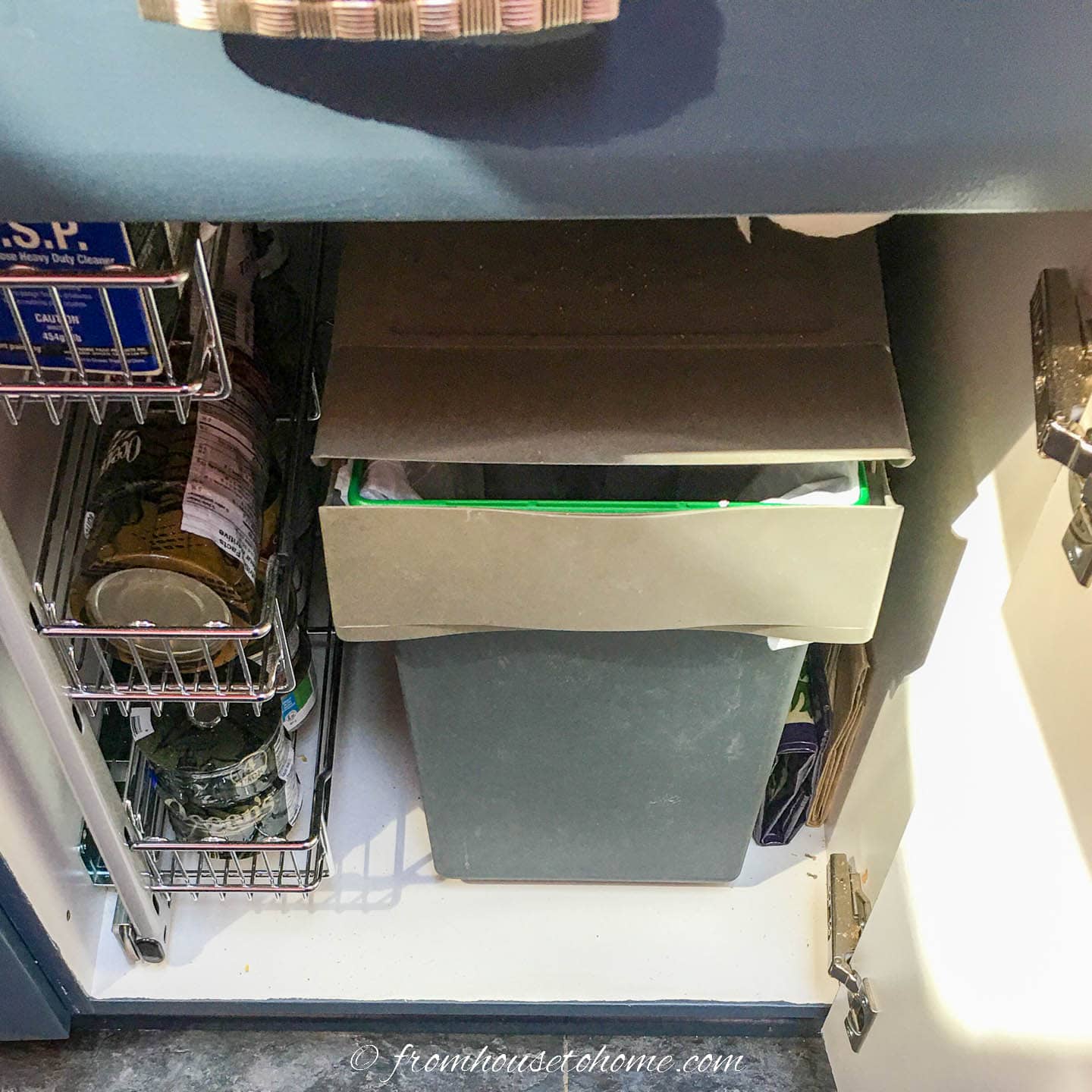 Pull out garbage can with a cover inside the kitchen cabinet