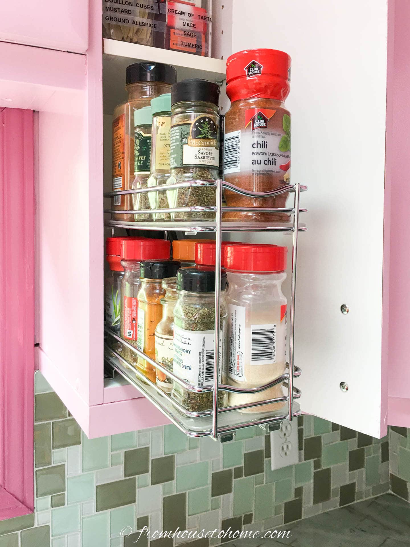 Spices stored in a narrow kitchen cabinet on a pull-out rack