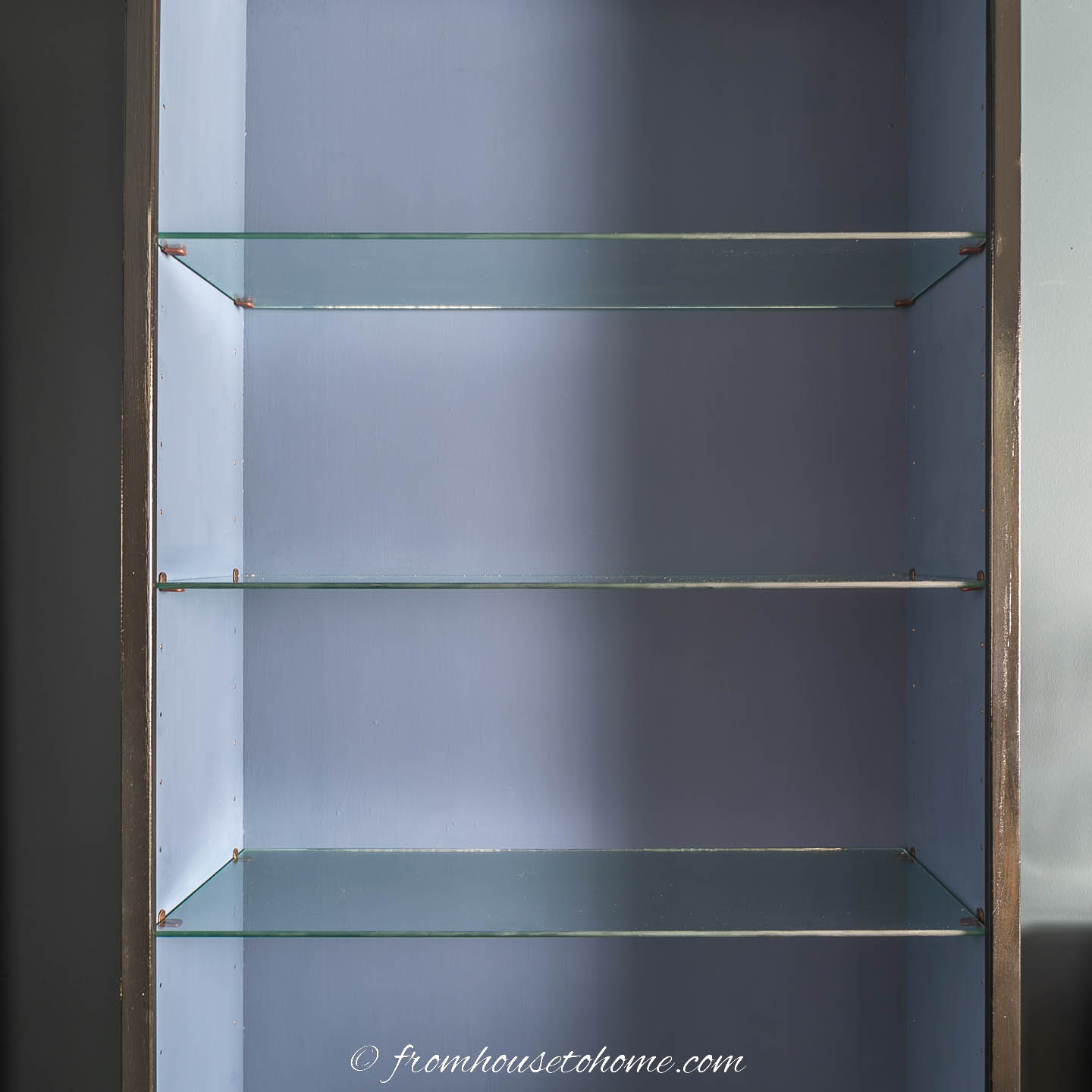 Glass shelves installed in the black and blue bookshelf