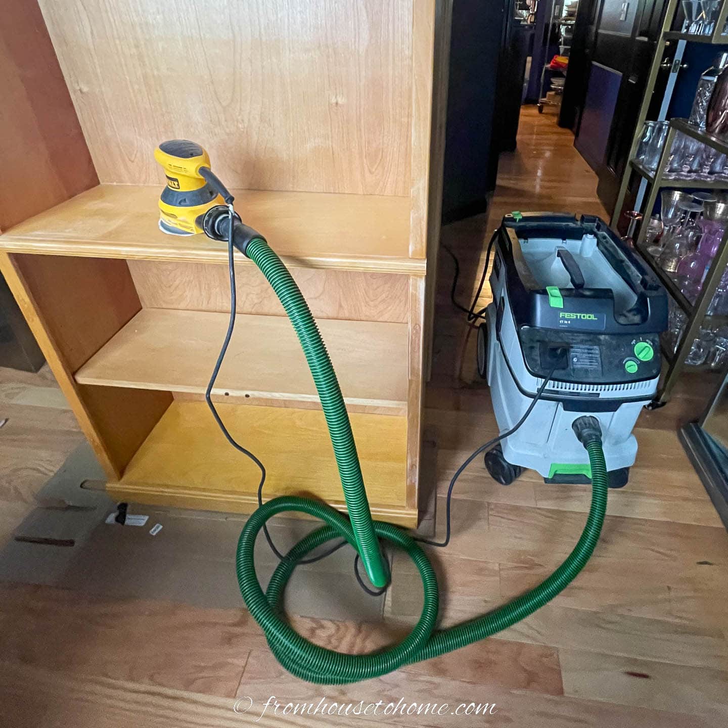 Bookcase with an electric sander connected to a dust collector