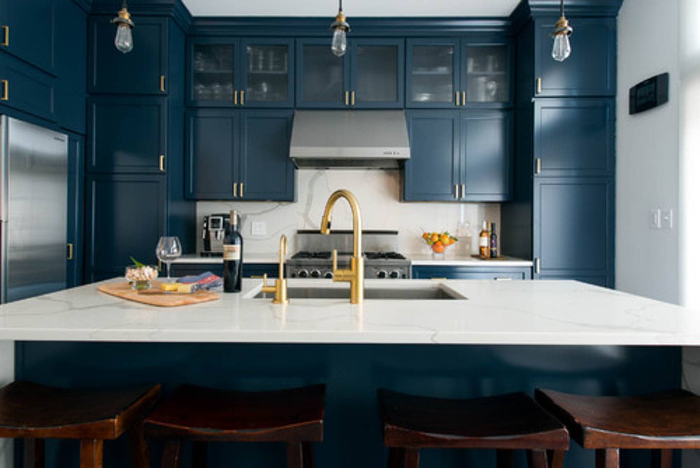 Kitchen with Hague Blue cabinets, white countertop and gold fixtures