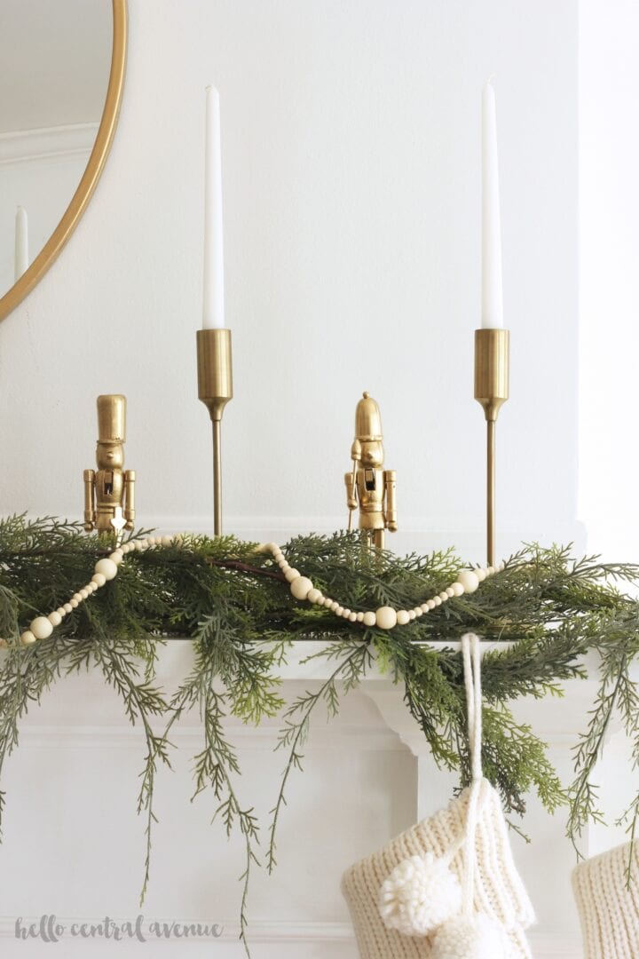 gold nutcracker decorations with candles on a fireplace mantel