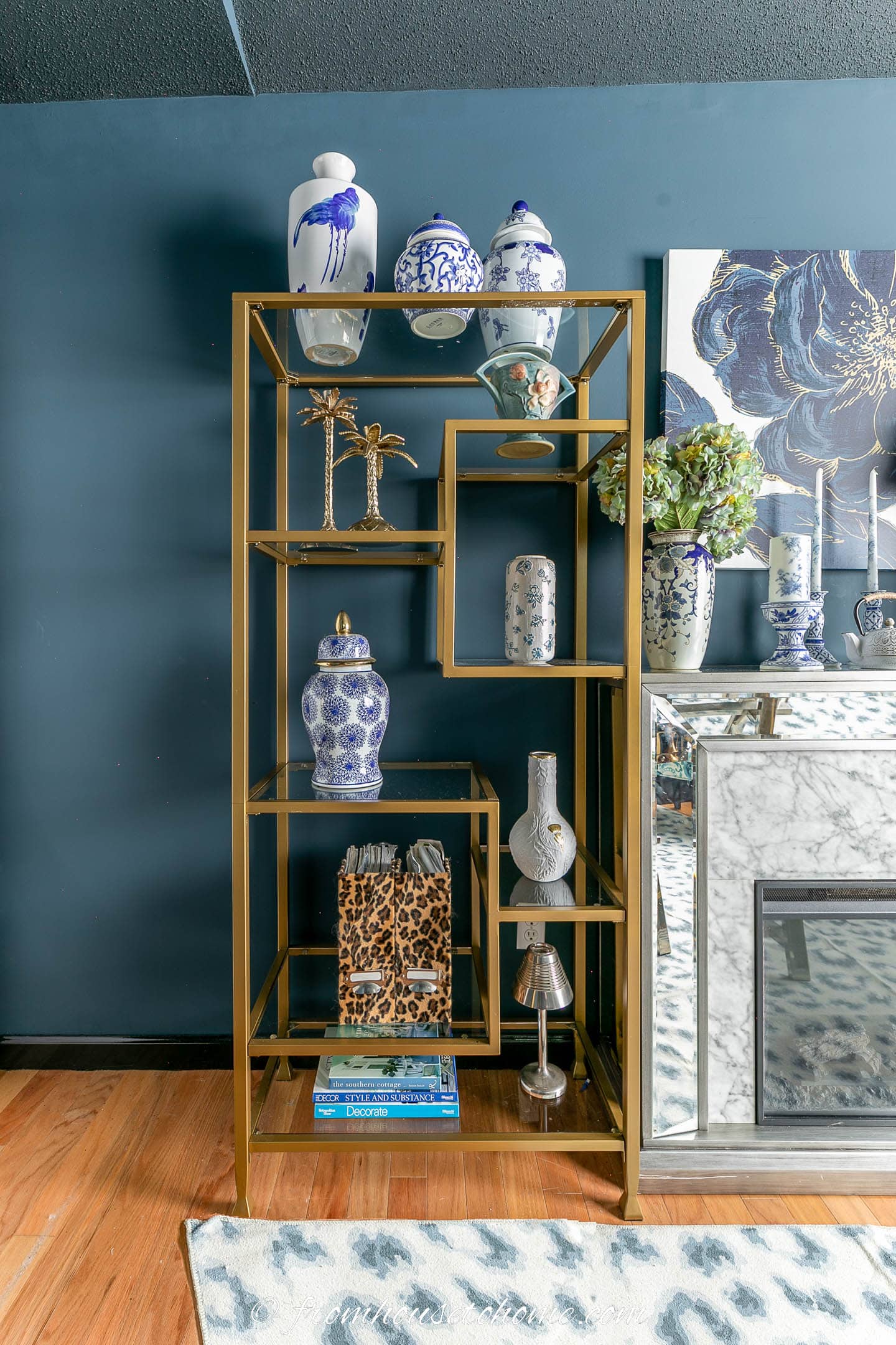A gold etagere shelf decorated with blue and white vases