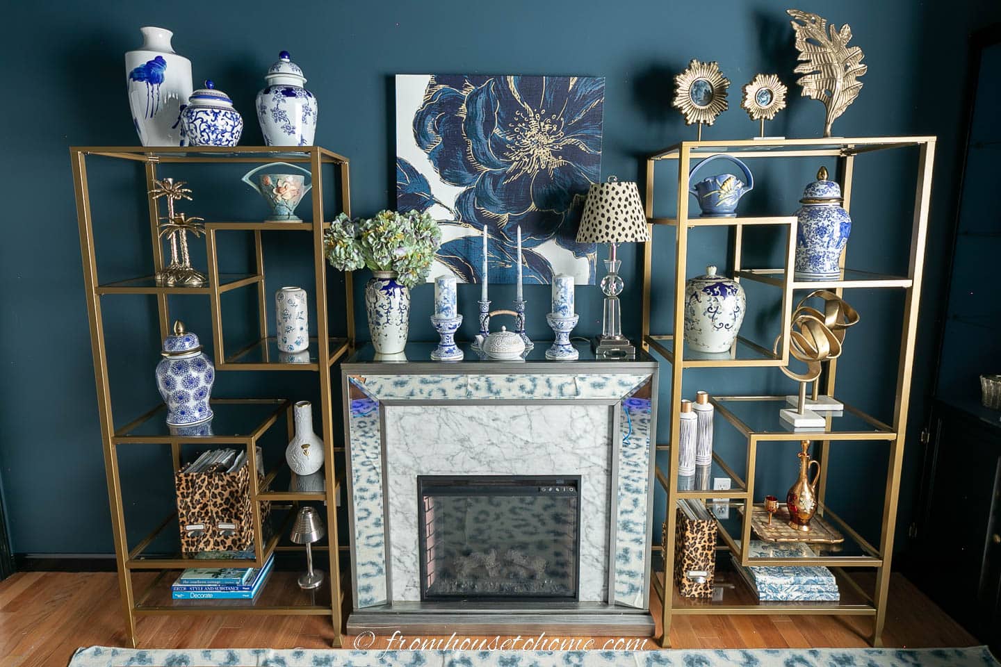 Electric fireplace between two gold etagere in an office with Hague Blue paint