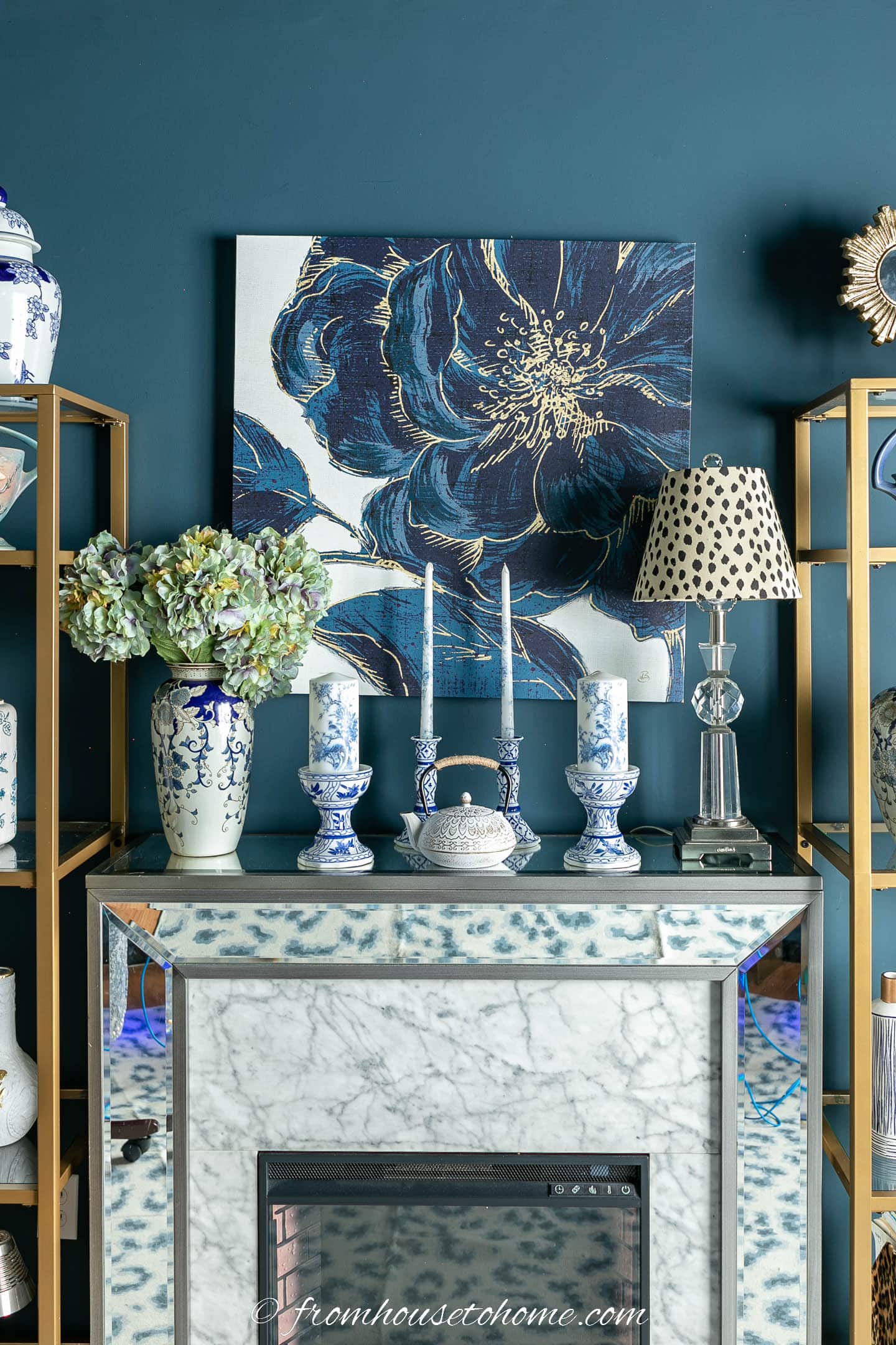 Fireplace mantel decorated with blue and white candles