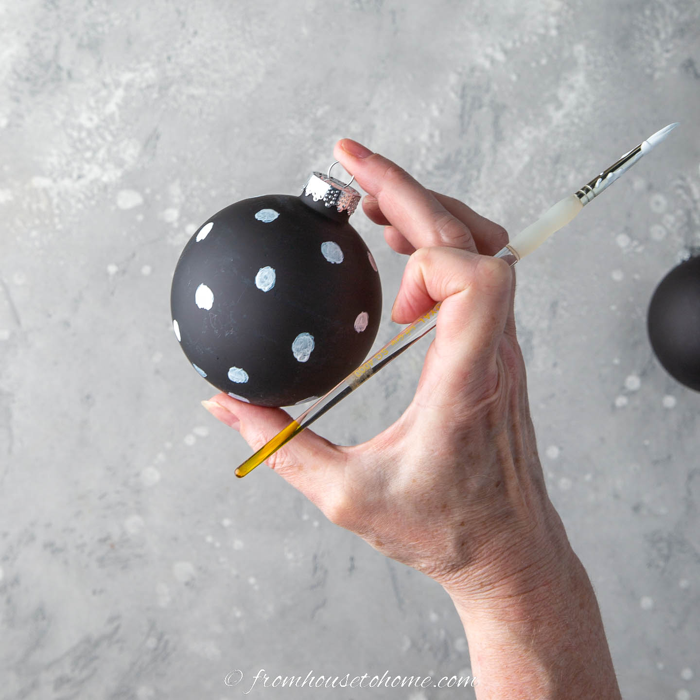 A black ornament painted with white polka dots