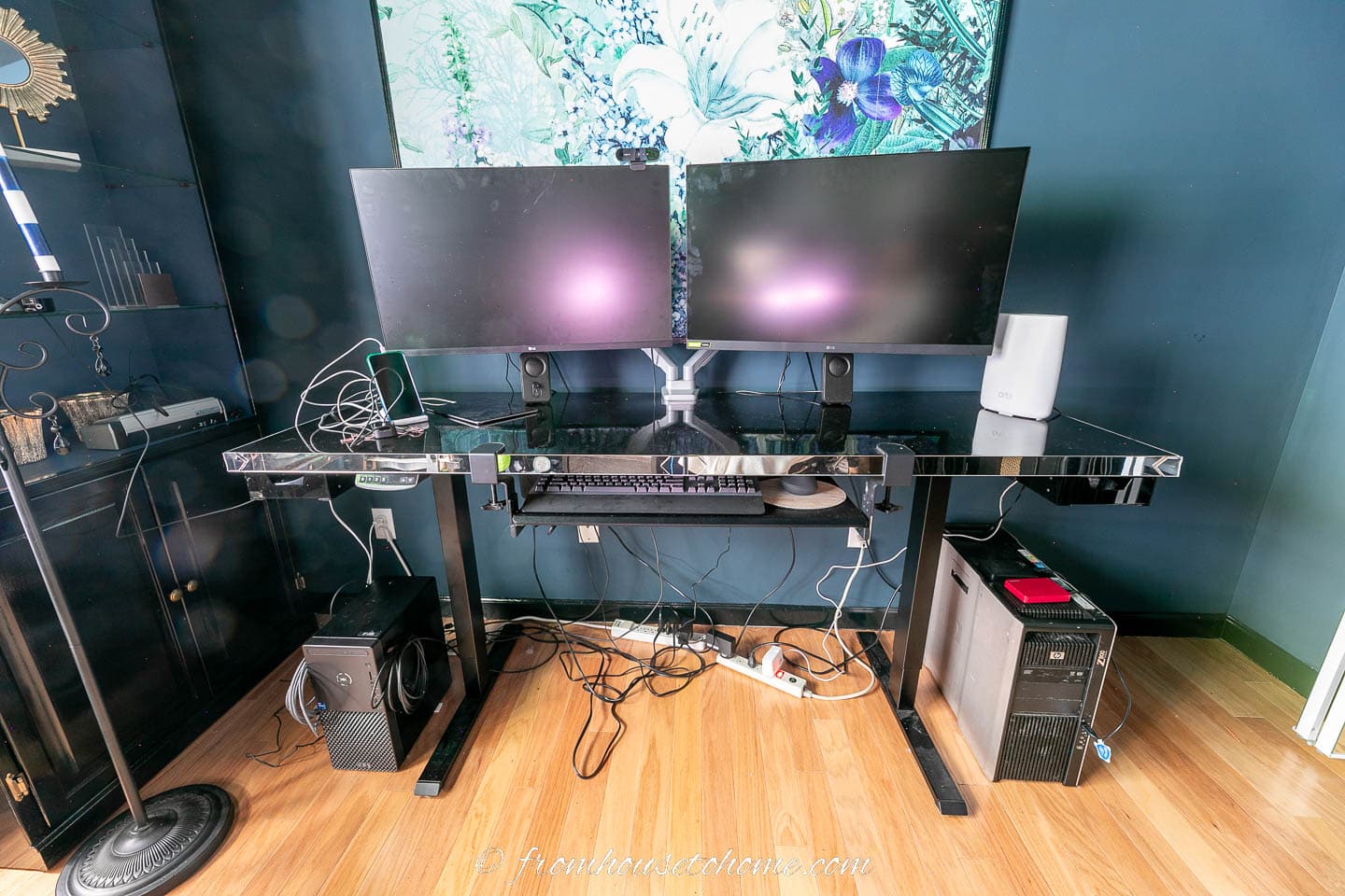 A computer desk with messy computer cords
