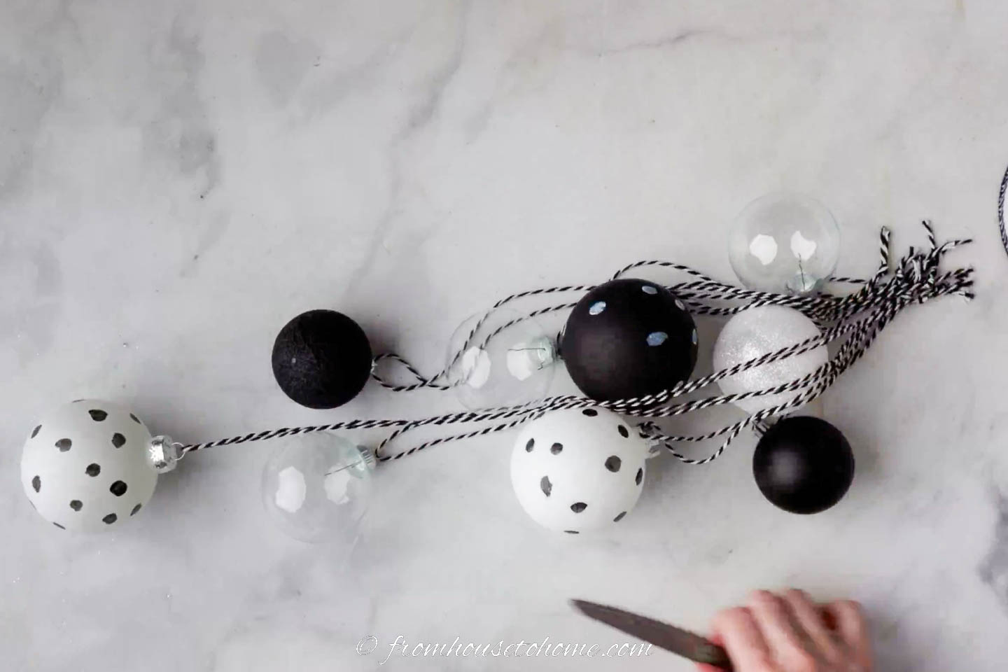 9 black and white ornaments with black and white string attached