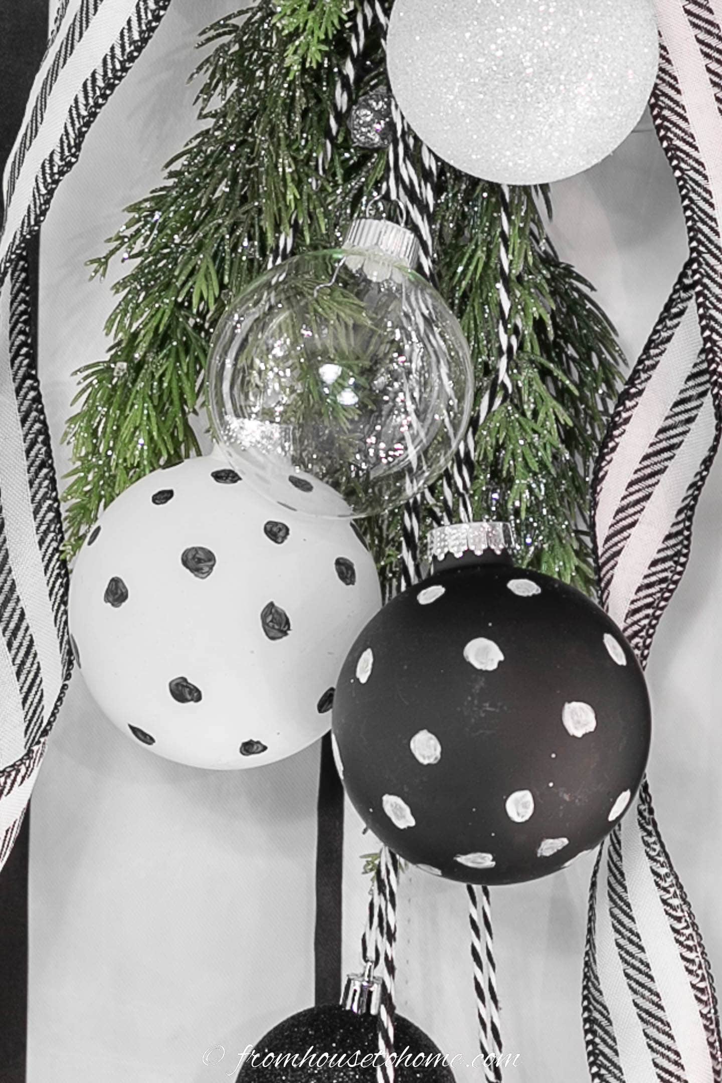 Close up of the black and white ornaments and evergreens in the Christmas swag