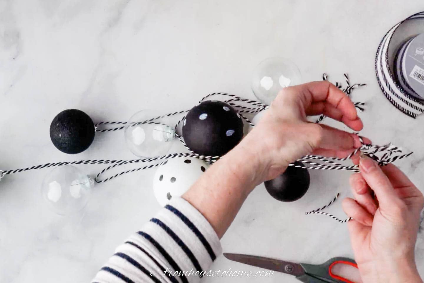 black and white ornaments being tied together with string