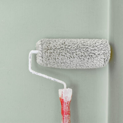 paint roller on a wall with green paint