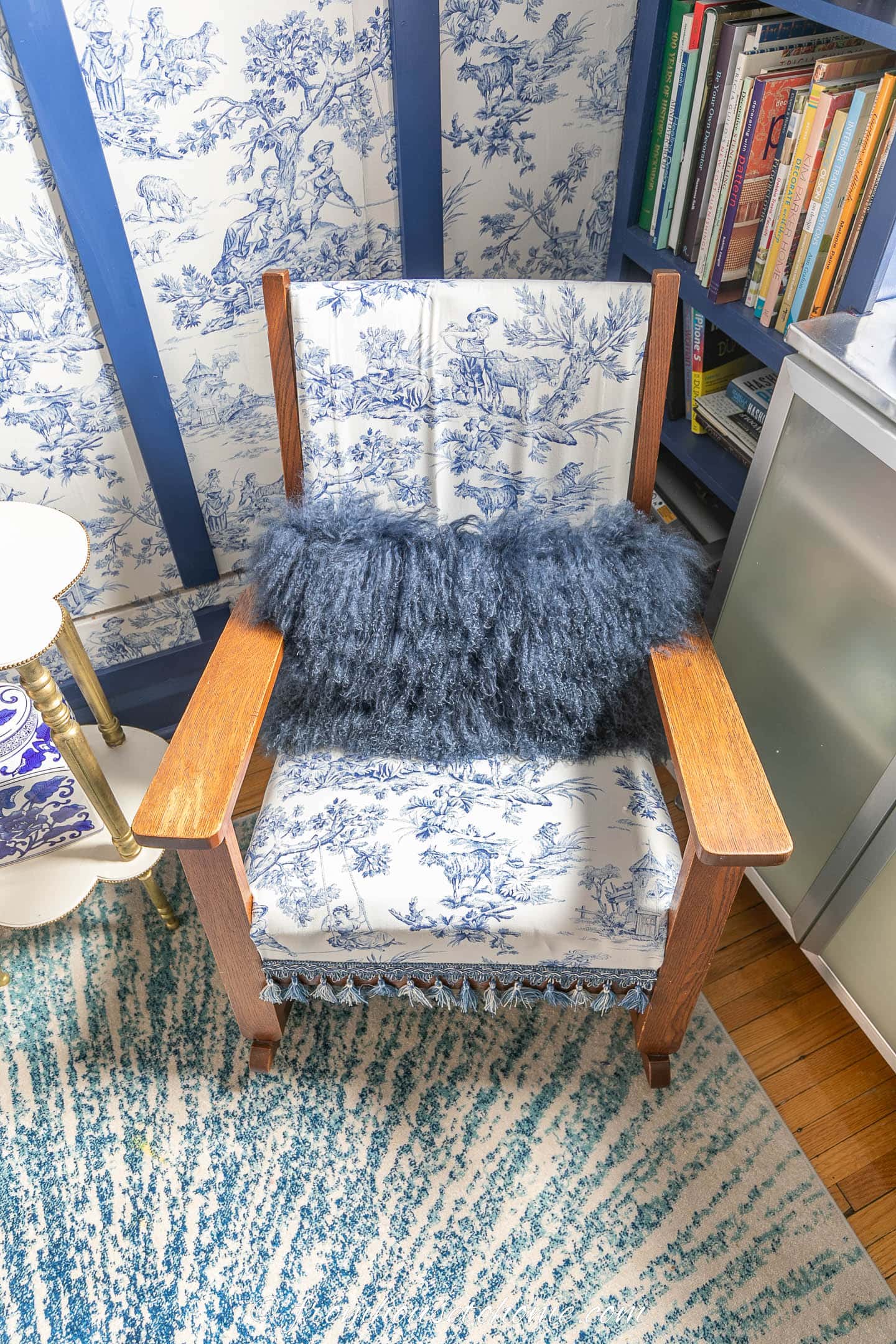 Blue and white toile slip cover on a wood rocking chair with a fluffy blue cushion