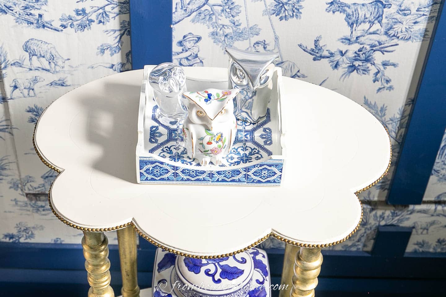 A small blue and white tray with 3 decorative owls on a small white table