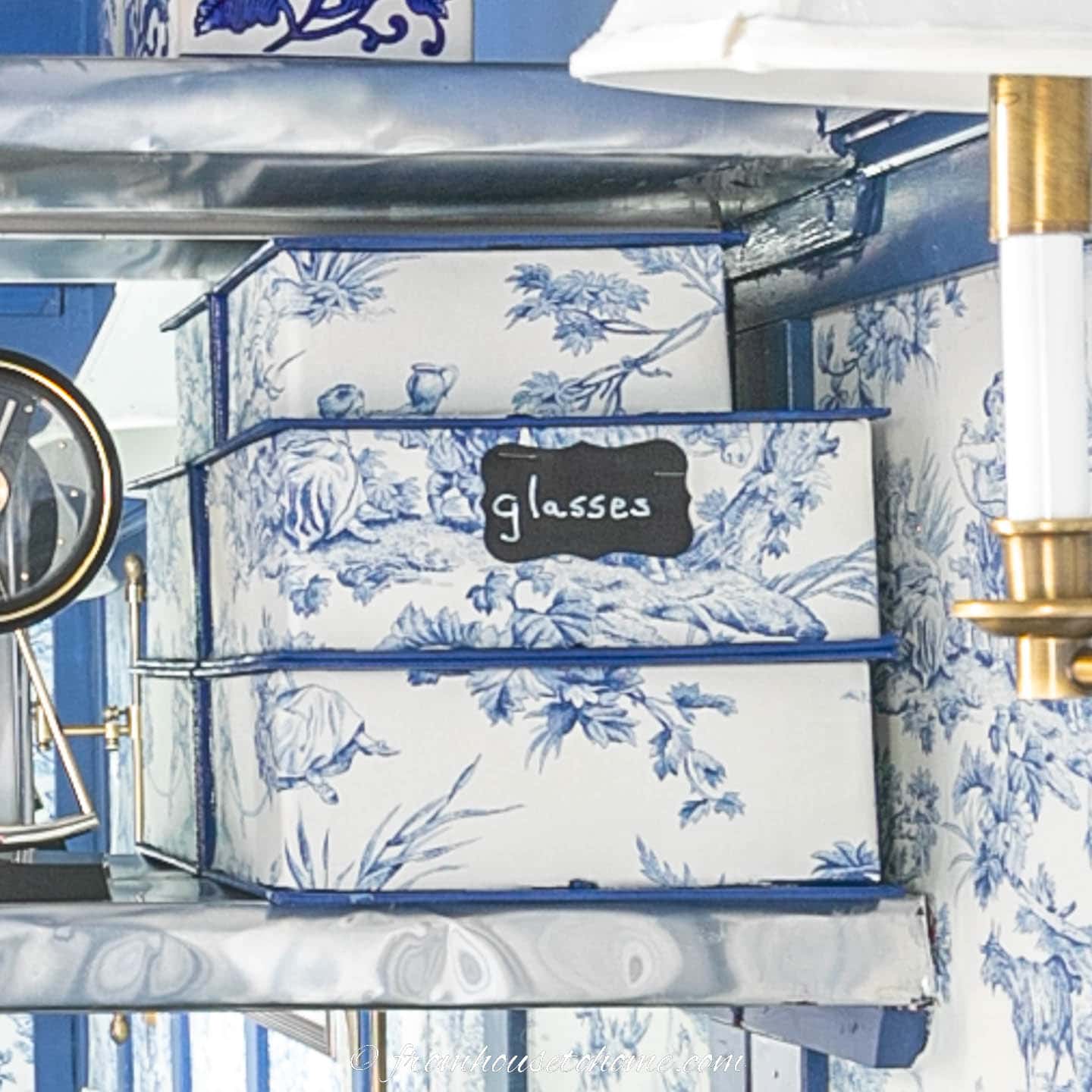 Small storage boxes covered with blue and white toile fabric