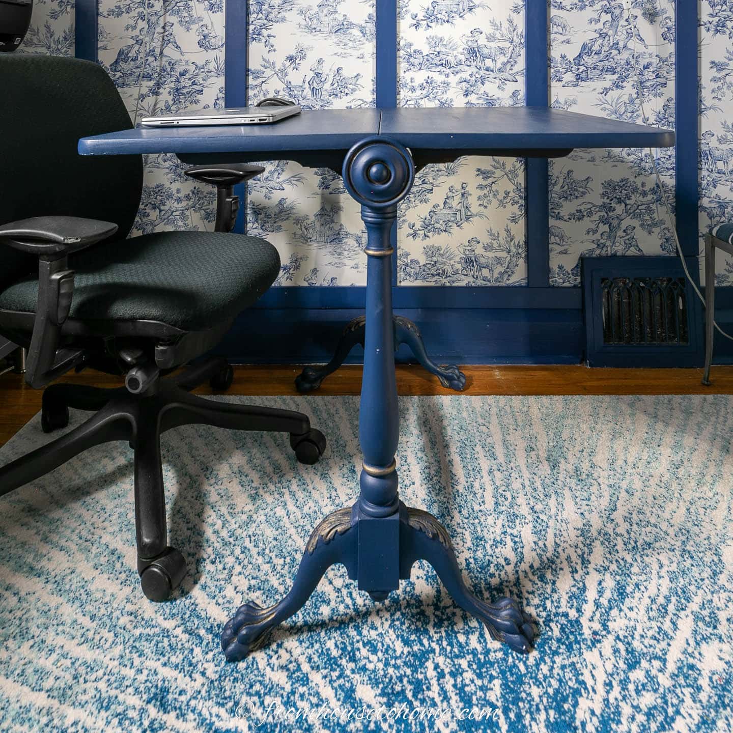 A small blue drop leaf table being used as a desk