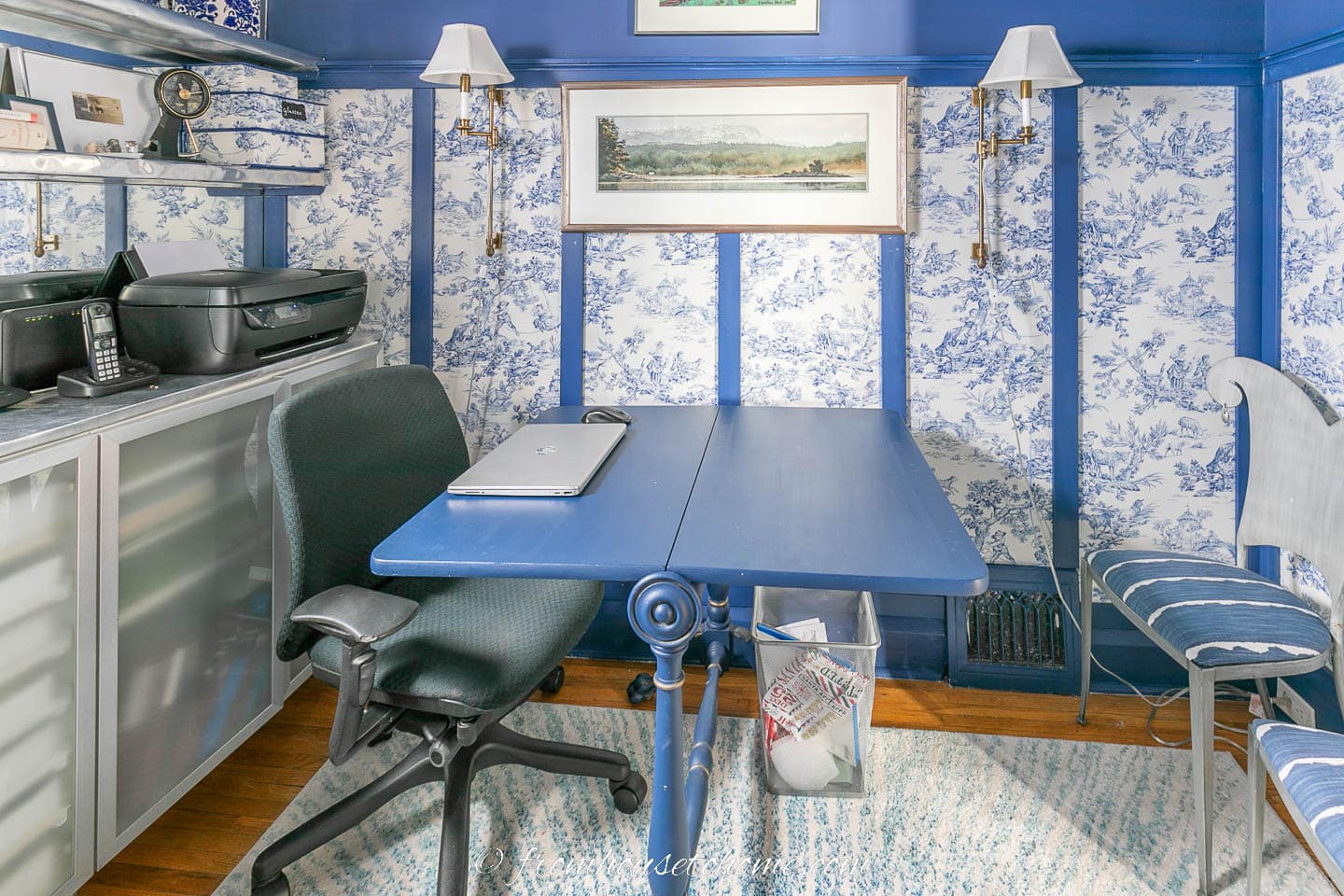 Small home office decorated in blue and white toile with a blue drop leaf table being used as a desk