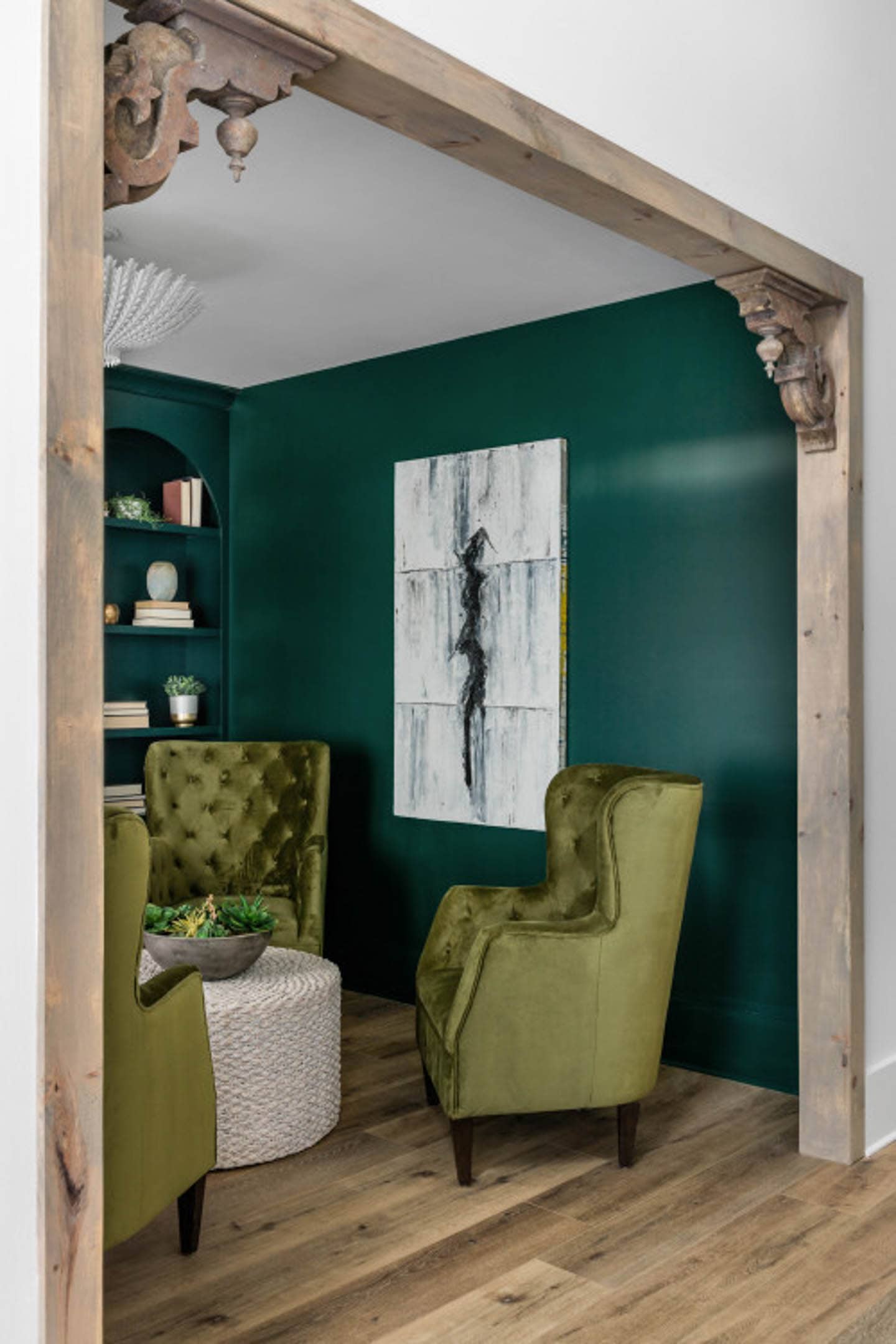 Small living room with green chairs around a white jute coffee table