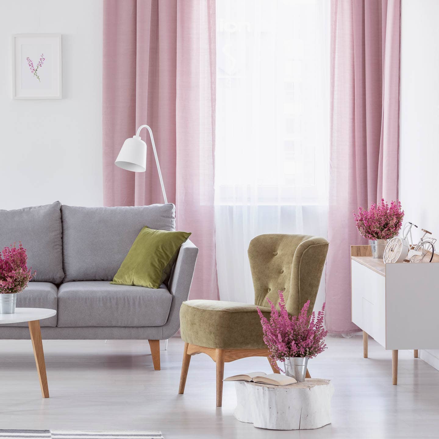 Small living room with gray sofa, green slipper chair and pink panel curtains
